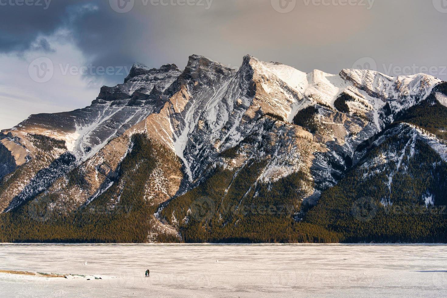 Beautiful frozen Lake Minnewanka with rocky mountains in winter on the evening at Banff national park photo