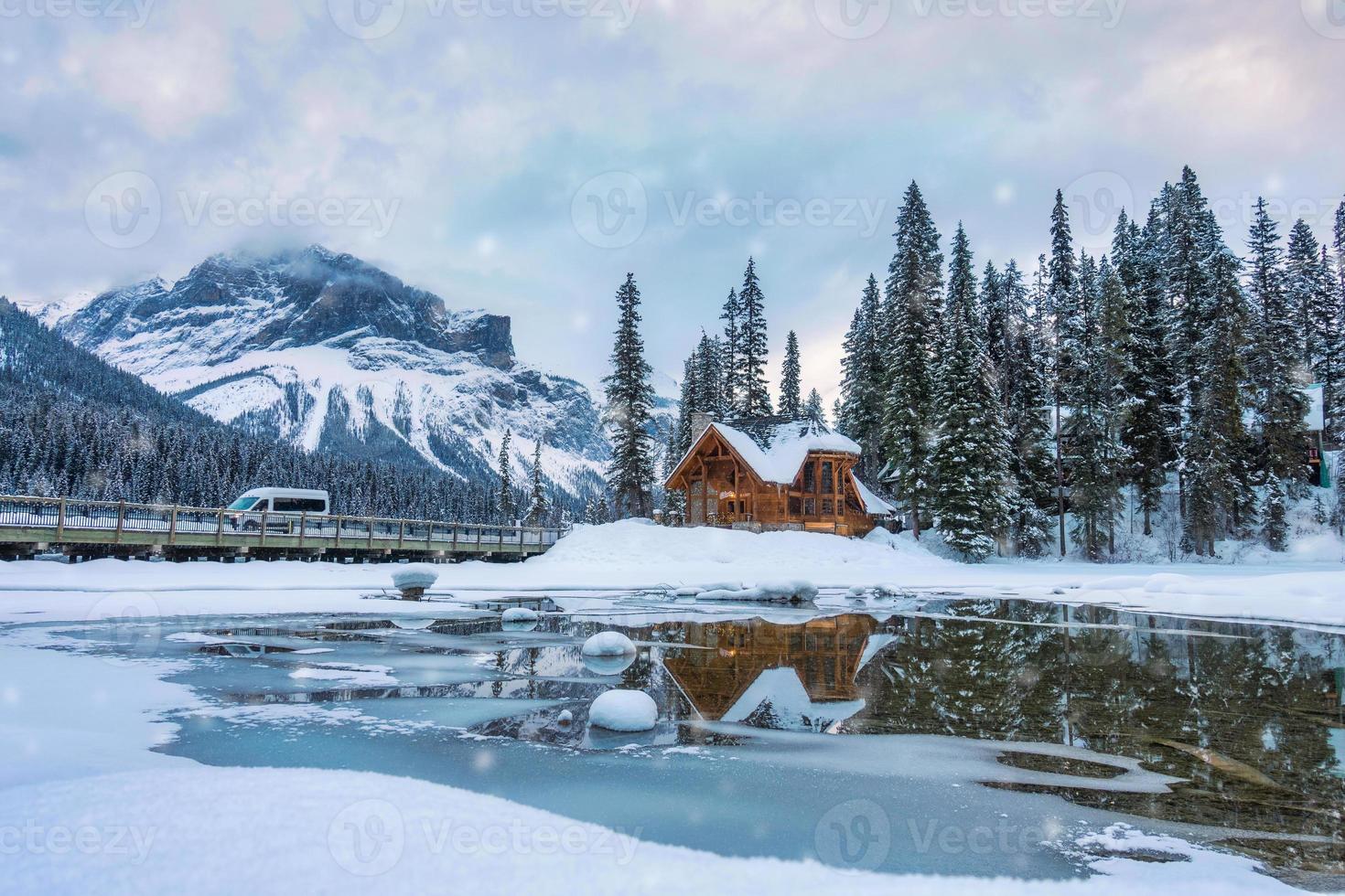 Emerald Lake with wooden lodge glowing and snowfall in pine forest on winter at Yoho national park photo