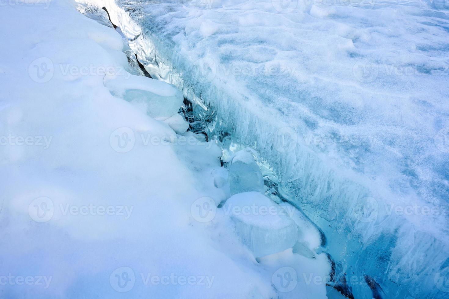 Cracked frozen lake surface in winter photo