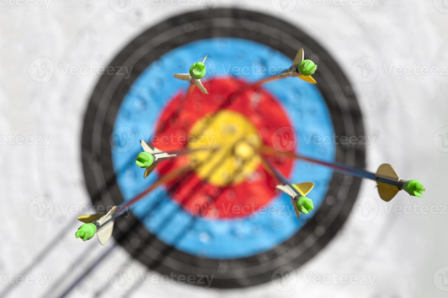 One out of six arrows in the bull's-eye of a sports target photo