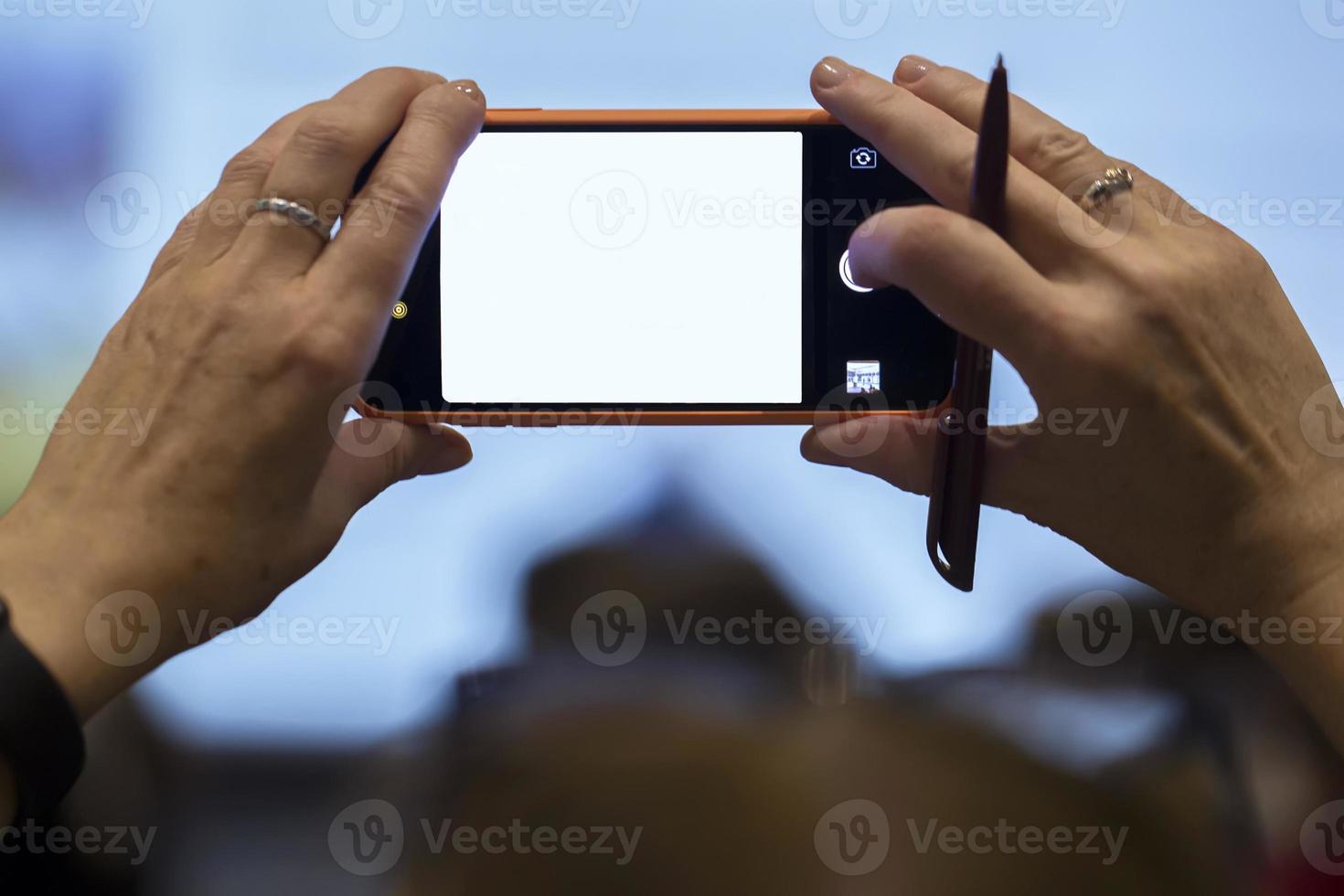 26.09. 2019 Belarus, the city of Minsk. Meeting and conference of bank employees.Hands hold a phone with a blank screen. Glowing blank smartphone screen. photo