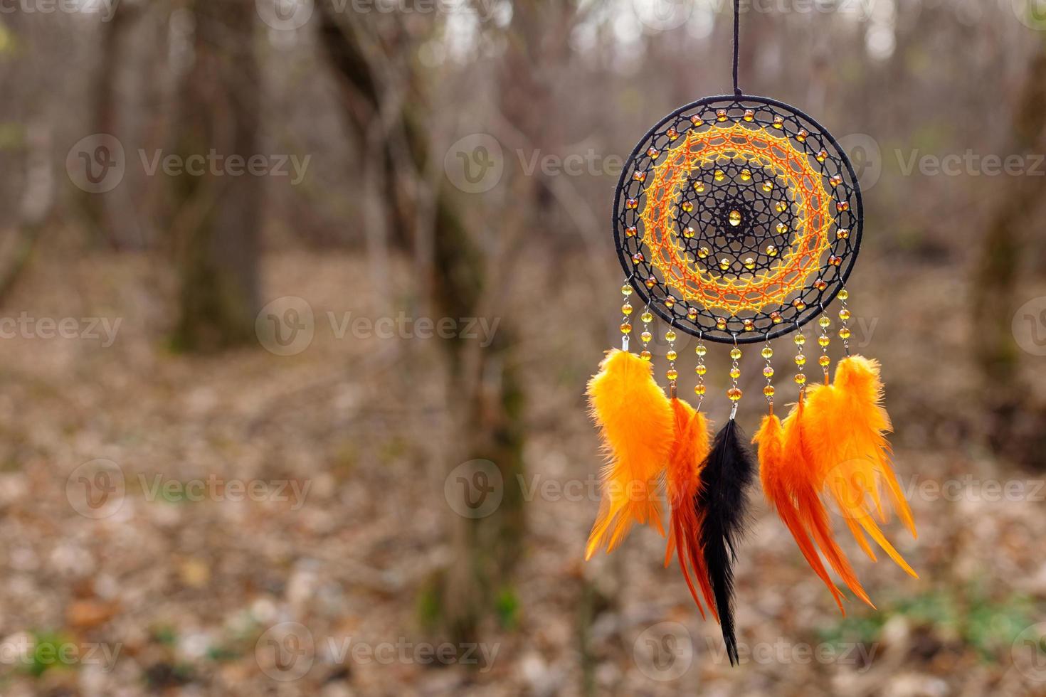 atrapasueños hecho a mano con hilos de plumas y cuerda de cuentas colgando foto