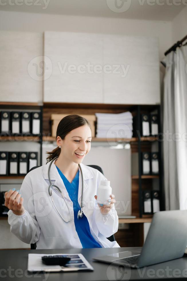 atractivo hembra médico hablando mientras explicando médico tratamiento a paciente mediante un vídeo llamada con ordenador portátil en oficina foto