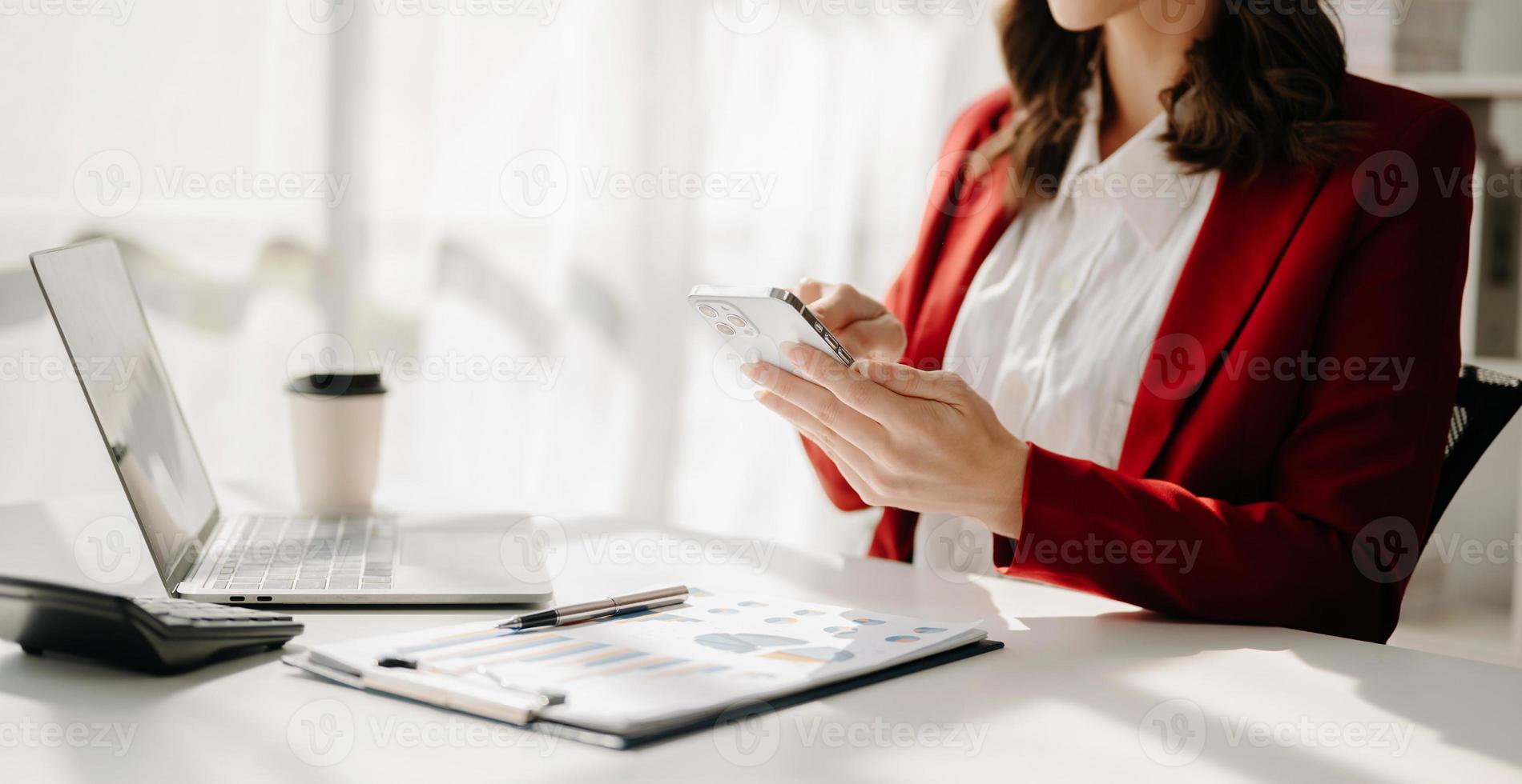 confidente mujer de negocios trabajando en computadora portátil, tableta y tableta a su lugar de trabajo a oficina. foto