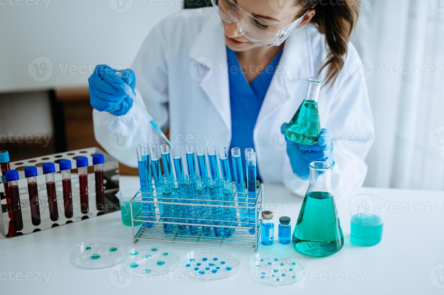 científico mezclando líquidos químicos en el laboratorio de química. investigador que trabaja en el laboratorio químico foto