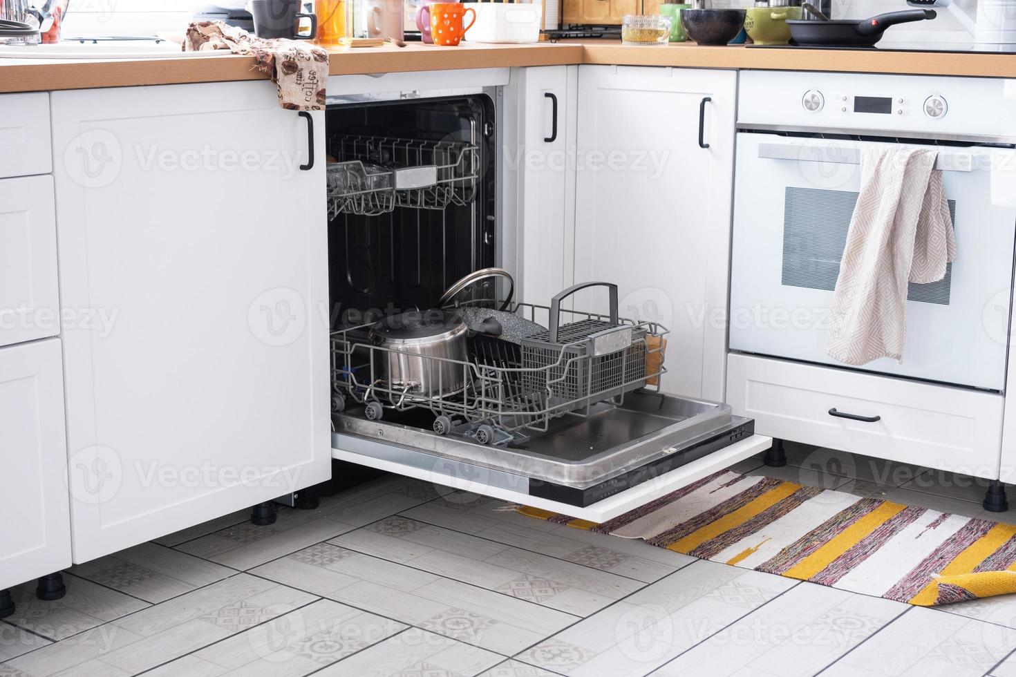 A mess in the kitchen, dirty dishes on the table, scattered things, unsanitary conditions. The dishwasher is full, the kitchen is untidy, everyday life photo