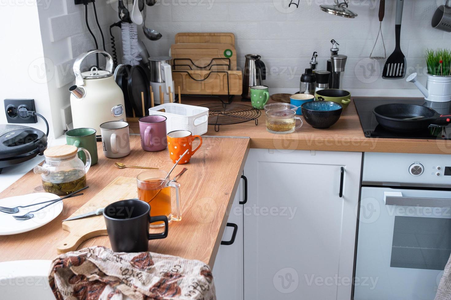 un lío en el cocina, sucio platos en el mesa, dispersado cosas, antihigiénico condiciones. el lavavajillas es lleno, el cocina es desordenado, todos los días vida foto