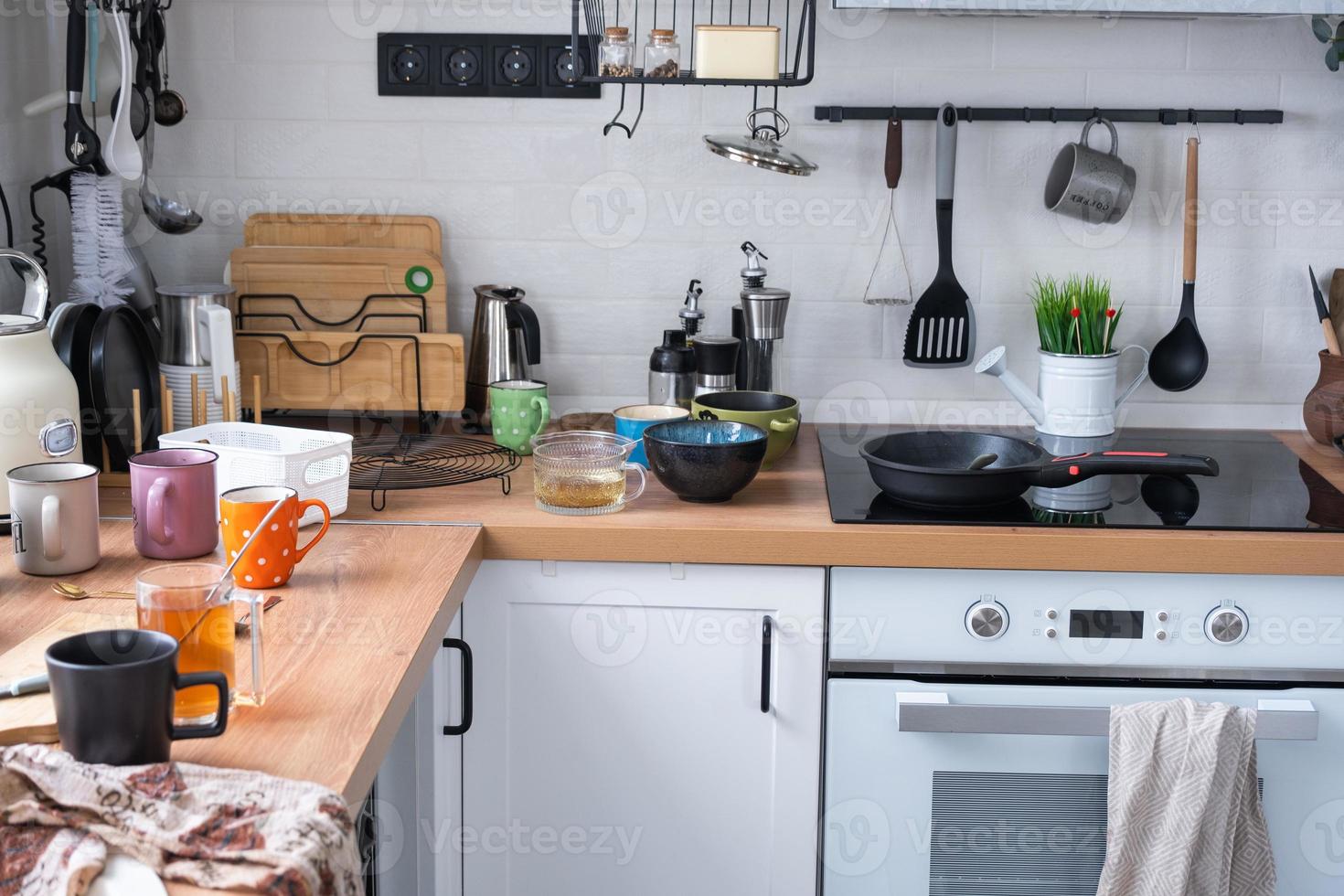 un lío en el cocina, sucio platos en el mesa, dispersado cosas, antihigiénico condiciones. el lavavajillas es lleno, el cocina es desordenado, todos los días vida foto