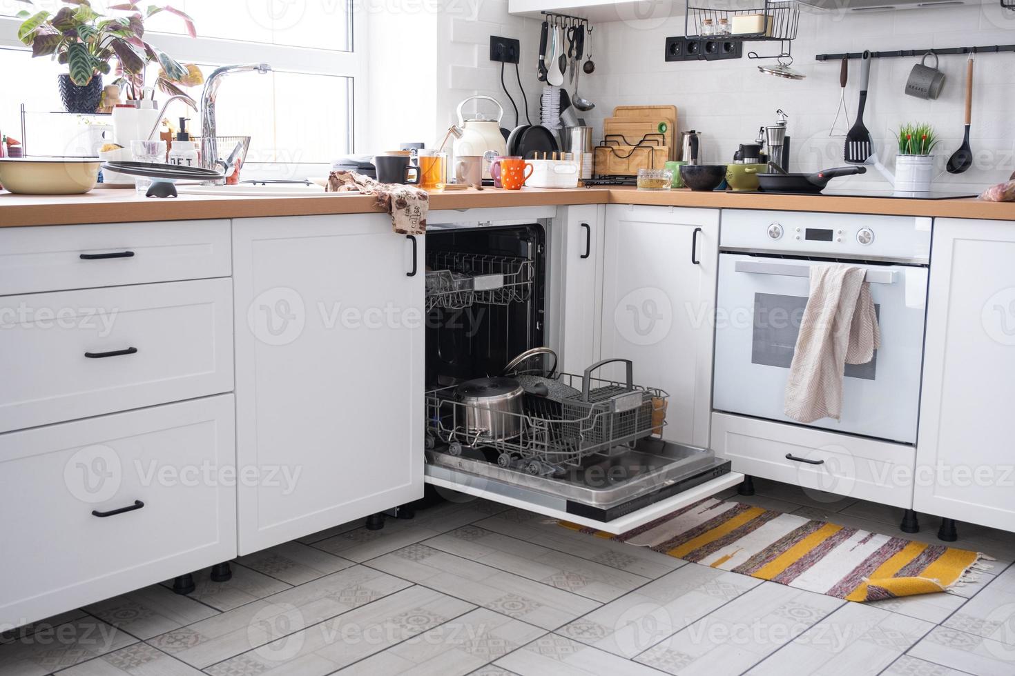 A mess in the kitchen, dirty dishes on the table, scattered things, unsanitary conditions. The dishwasher is full, the kitchen is untidy, everyday life photo