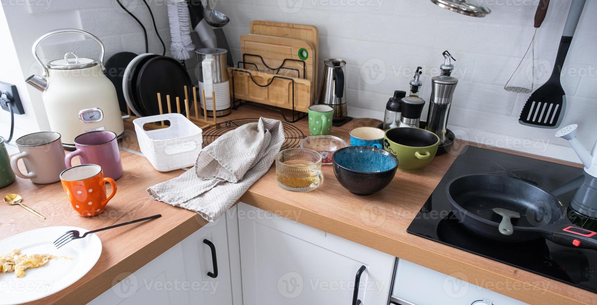 A mess in the kitchen, dirty dishes on the table, scattered things, unsanitary conditions. The dishwasher is full, the kitchen is untidy, everyday life photo