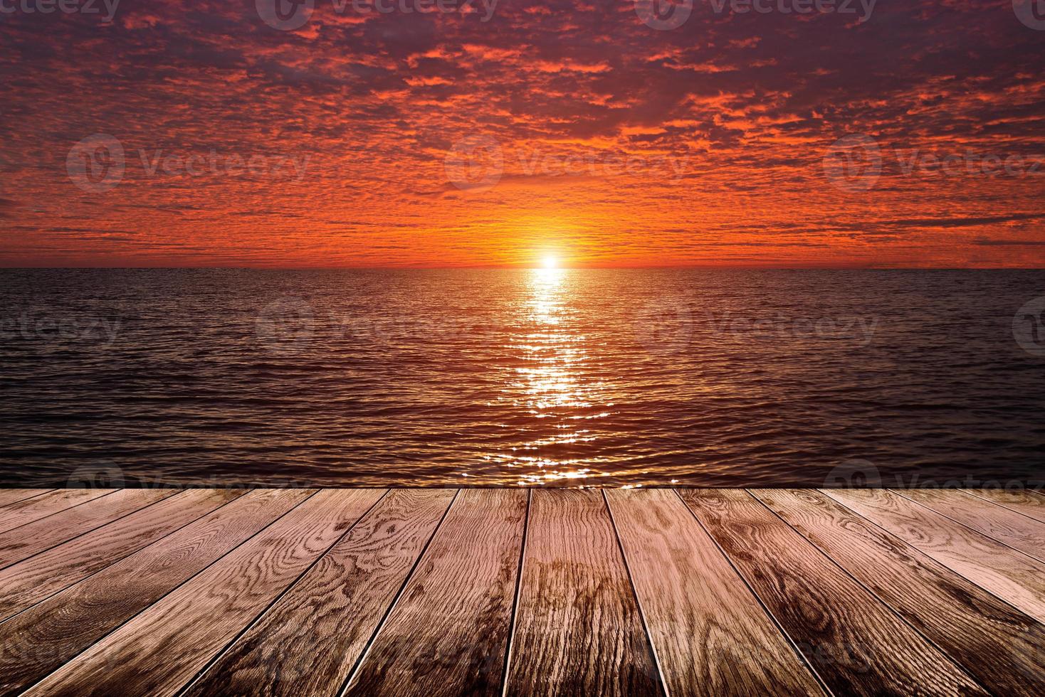 Wood floor with ocean with sunset or sunrise photo