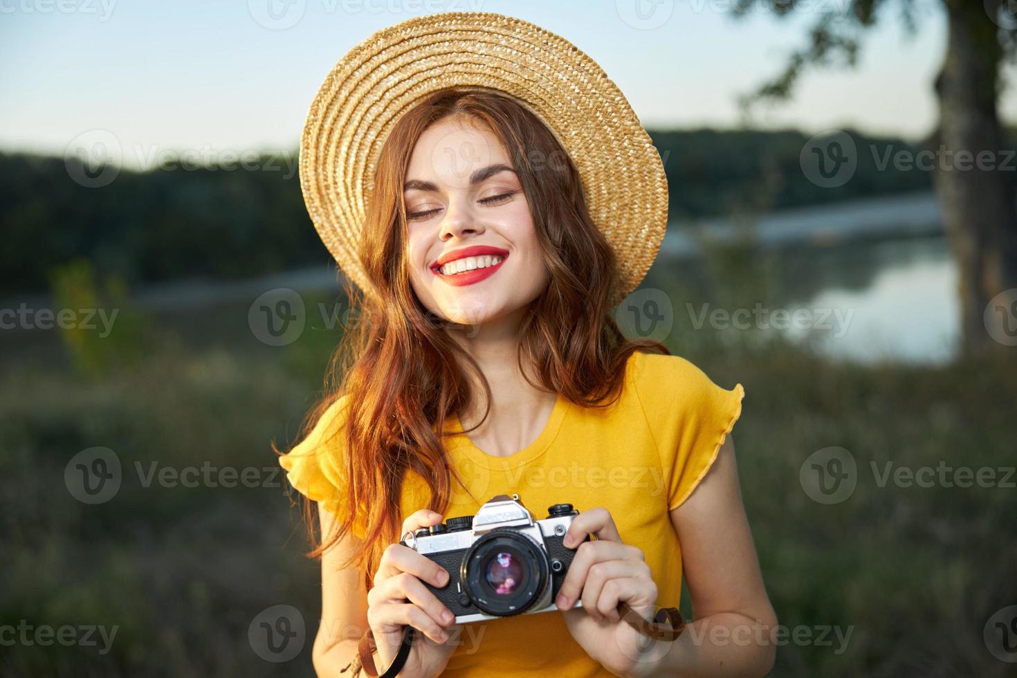 sonriente mujer con cámara en manos naturaleza viaje estilo de vida pasatiempo foto