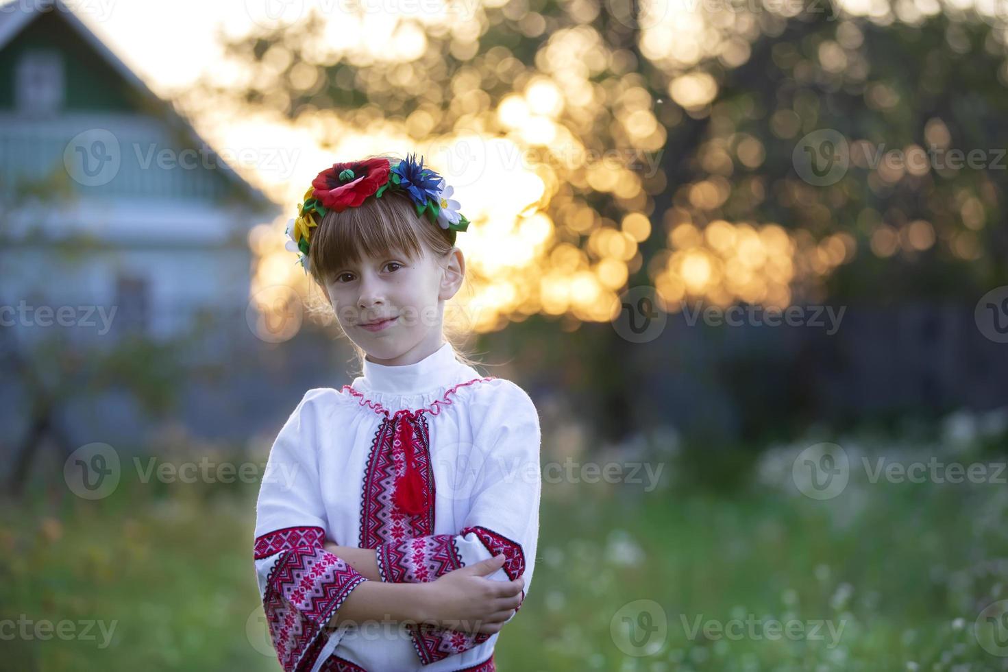 Beautiful little Slavic girl in national clothes on a bokeh background. Ukrainian or Belarusian child. photo