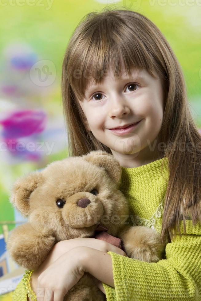 Portrait of a beautiful five year old girl with a toy bear. photo