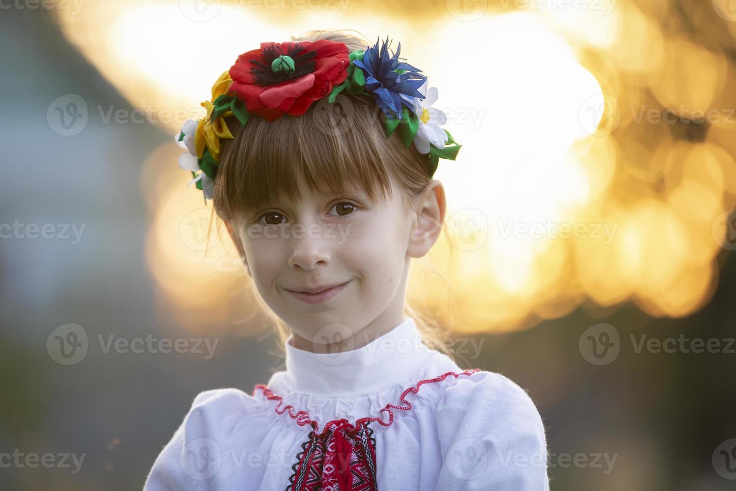 Beautiful little Slavic girl in national clothes on a bokeh background. Ukrainian or Belarusian child. photo