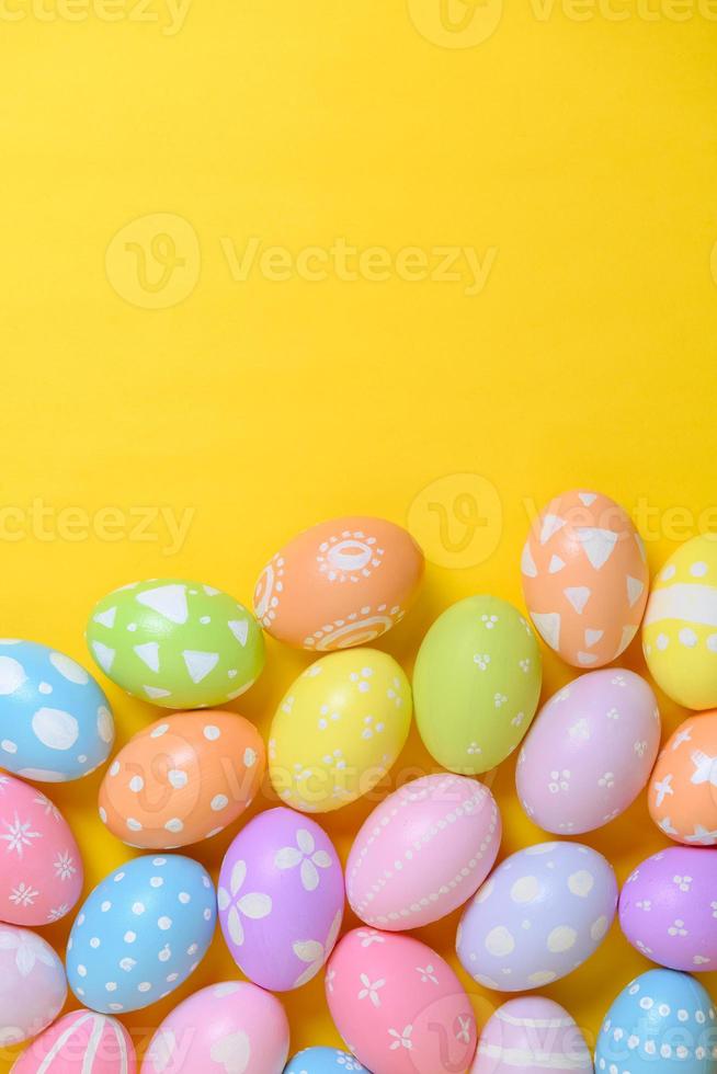 Happy easter holiday celebration concept. Group of painted colourful eggs decoration on a yellow background. Seasonal religion tradition design. Top view, flat lay, copy space. photo