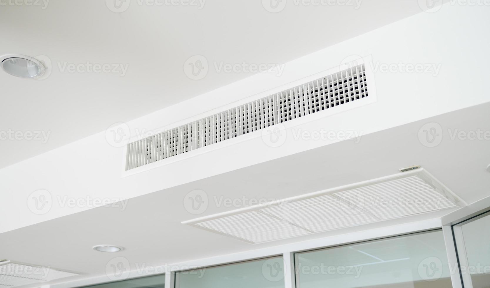 Ceiling mounted cassette type air conditioner and modern lamp light on white ceiling. duct air conditioner for home or office photo