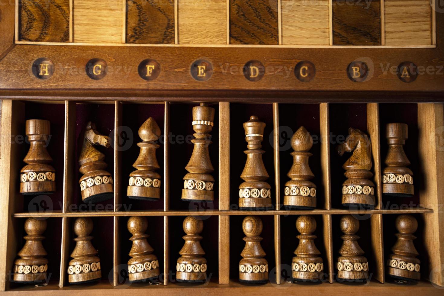 Dark chess pieces lie in a box. A puzzle game with tricky combinations that requires planning and thinking. photo