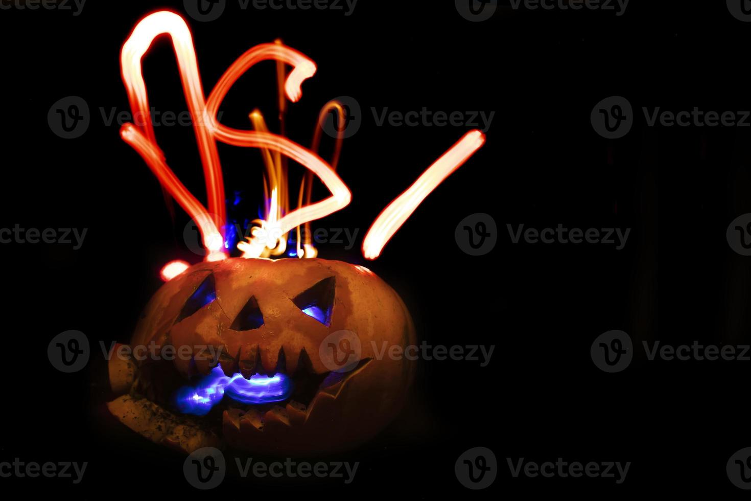 Glowing halloween pumpkin on a black background. photo