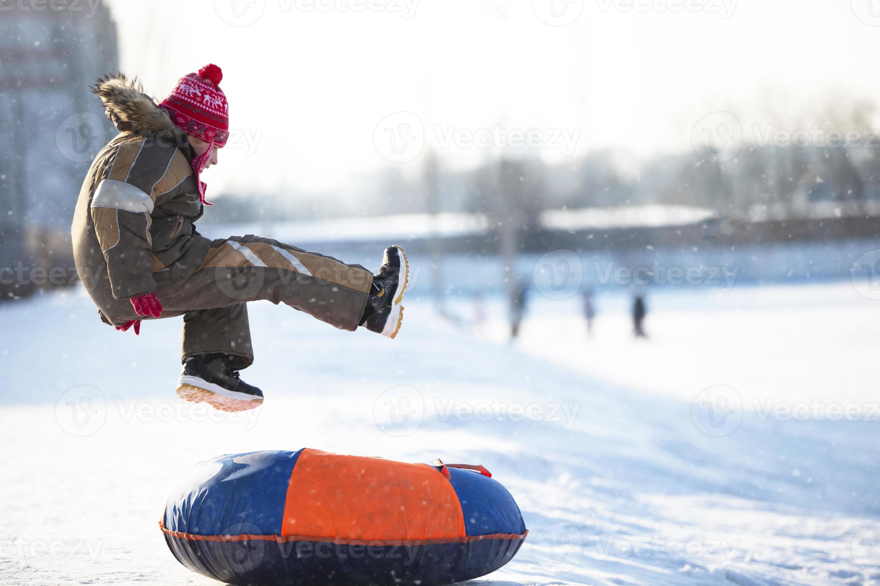 niño en invierno. el niño está en trineo. un niño cubierto de nieve sube  una montaña y tira de un trineo detrás de él. 19048301 Foto de stock en  Vecteezy