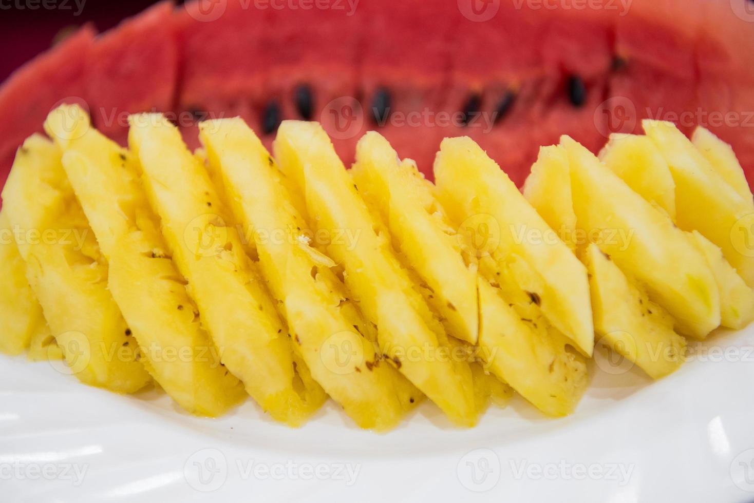 Sliced fruit stacks in watermelon and pineapple photo