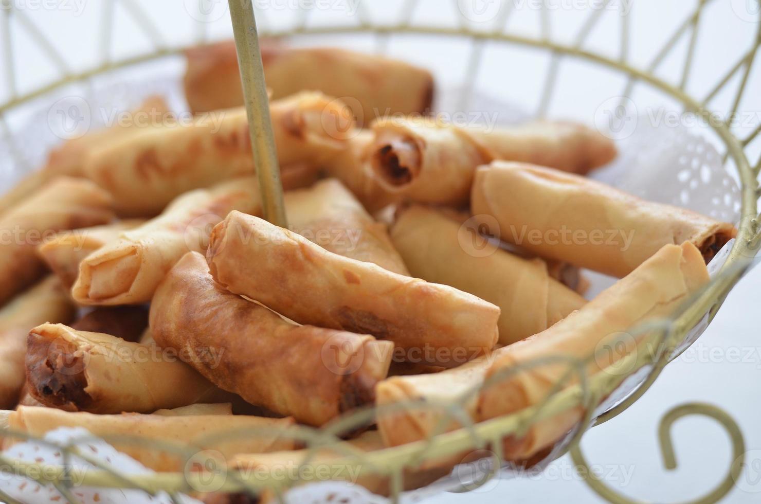 The delicious golden spring rolls serve in a wodden basket photo