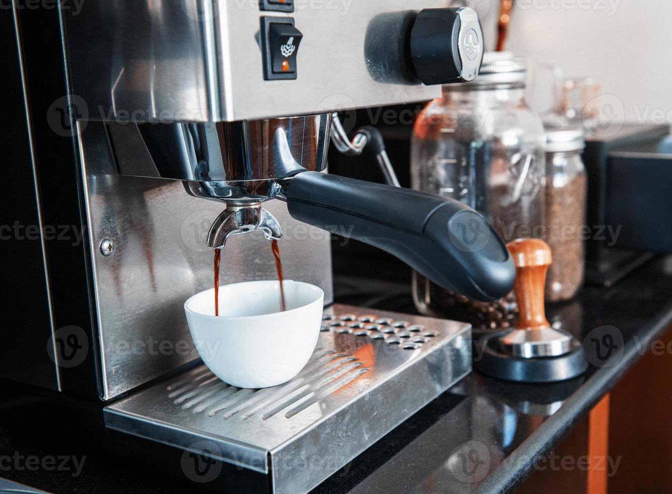 prepares espresso in his coffee shop photo