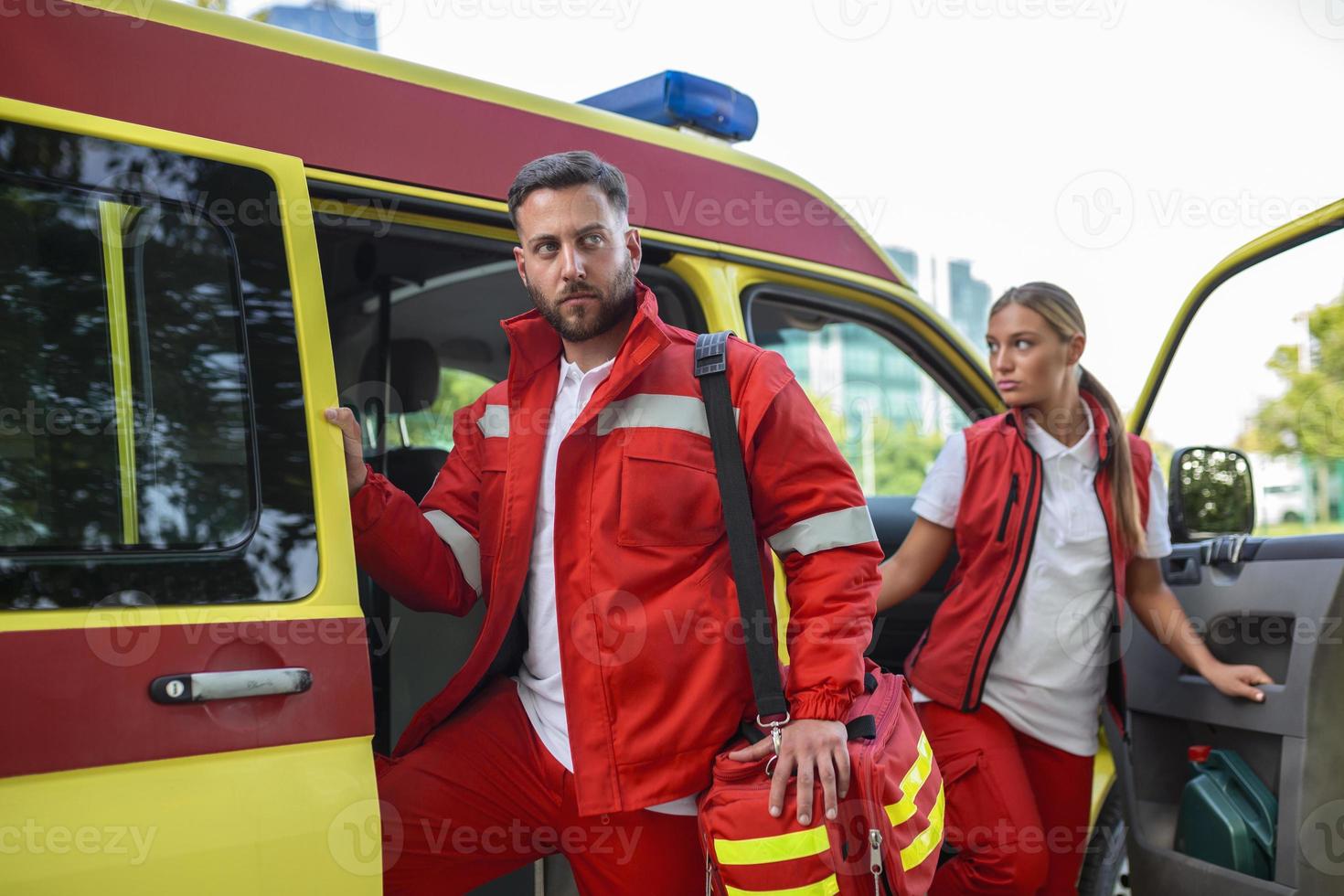 A team of paramedics is coming out of an ambulance, responding to an emergency call. photo