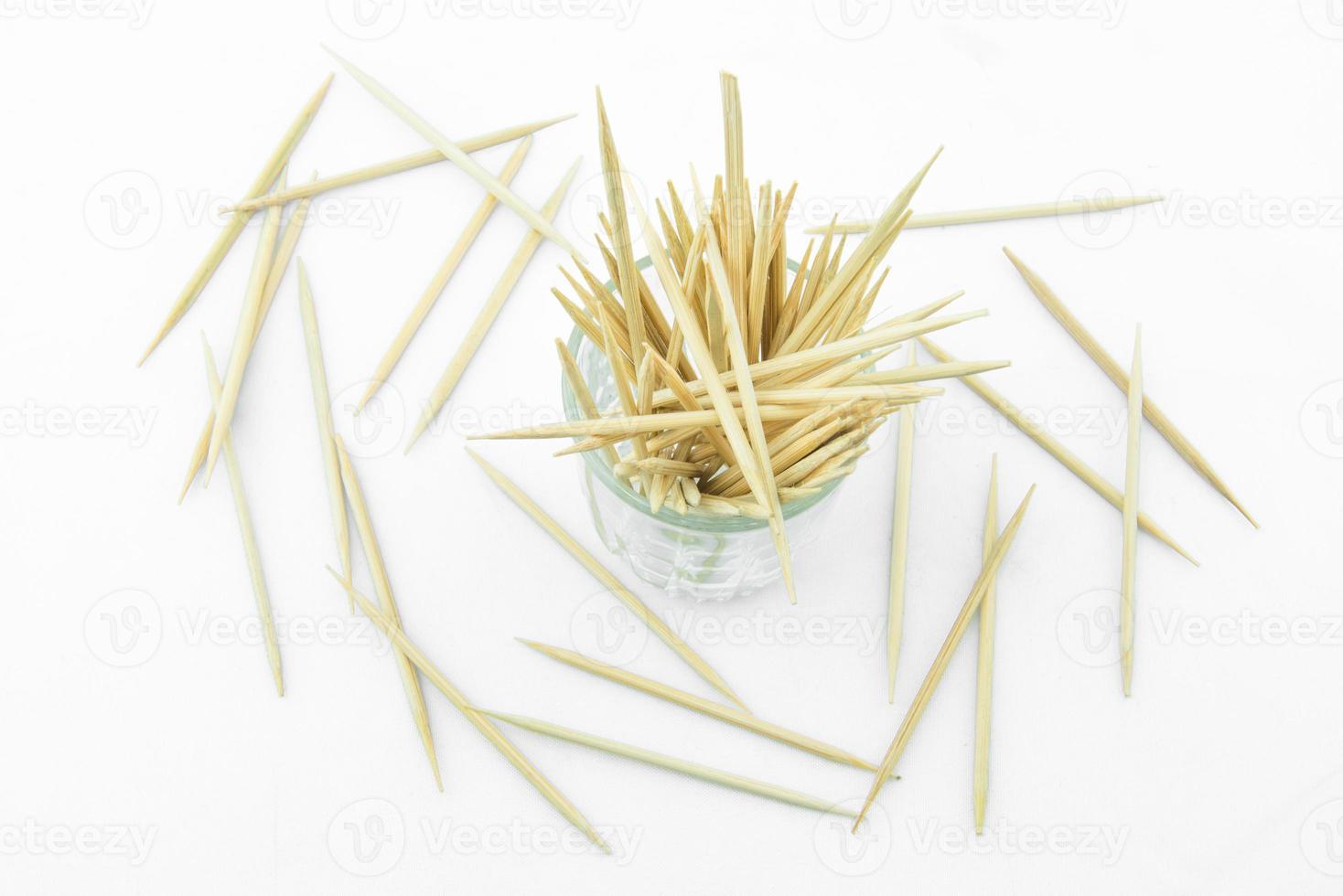 Toothpicks in transparent glass. Isolated on a white photo