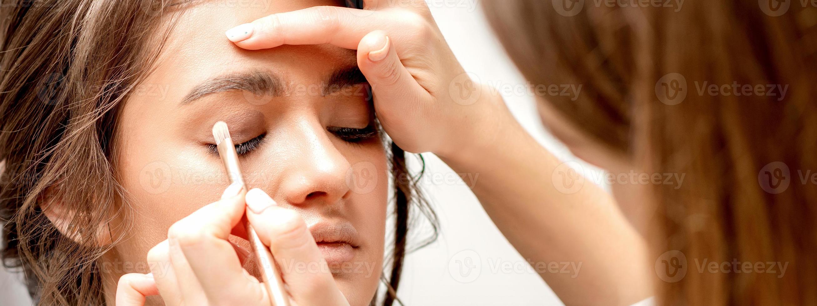 Makeup artist applies eye shadow photo