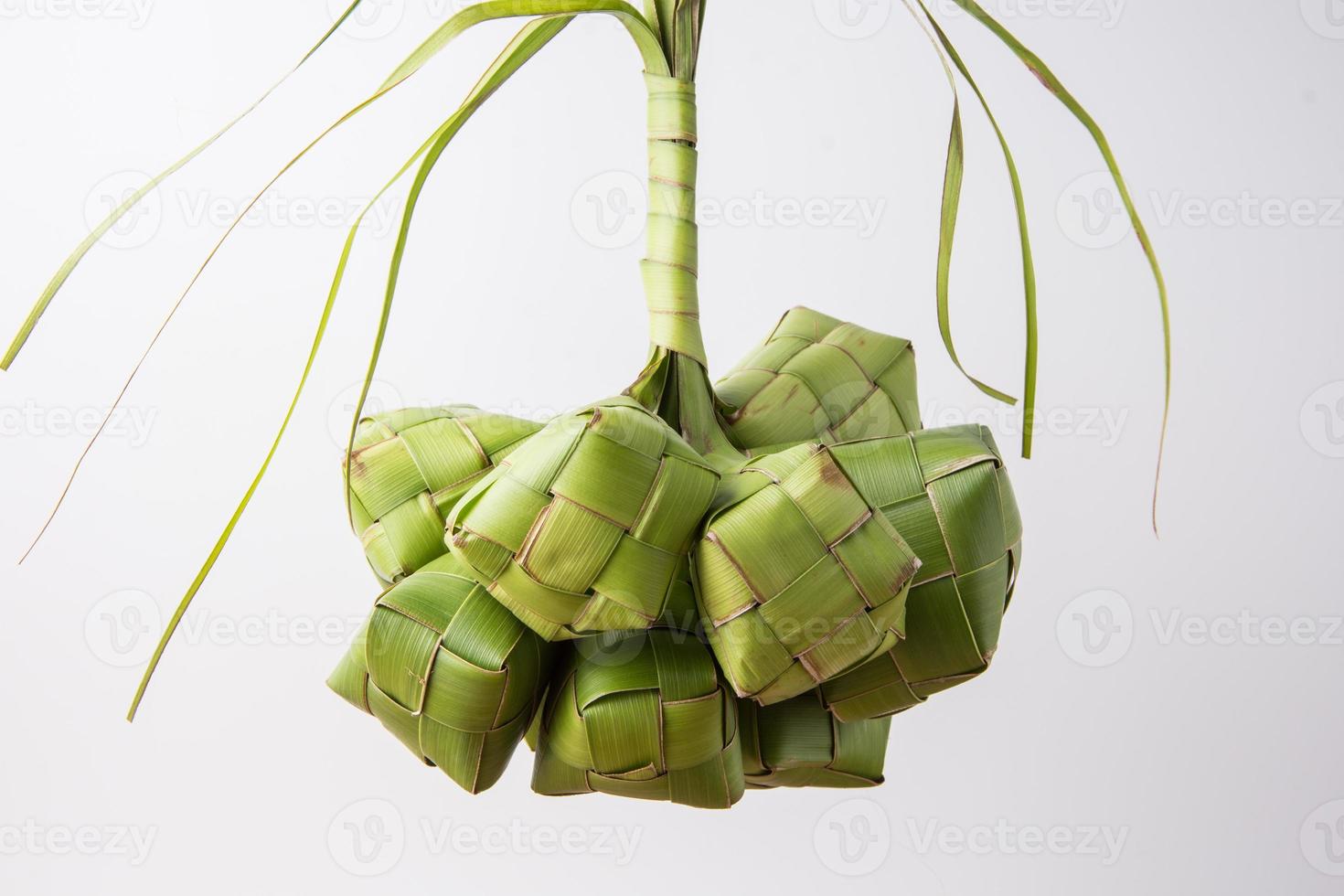 Ketupat lebaran is a typical Indonesian food during the festive season of Ketupat, Eid al Fitr, Eid al Adha, natural rice wrap made from young coconut leaves on a white background, empty space photo