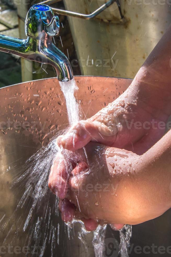 Asian boy washing hands on metal sink, Close up of washing hands under running water, Cleaning Hands.Hygiene concept. photo