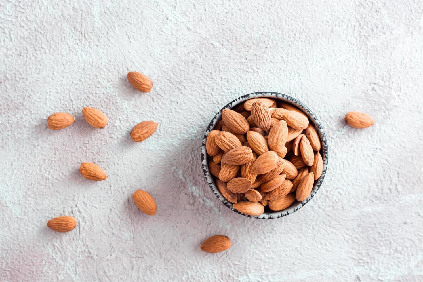 Fresh peeled almonds in a bowl on a light background. A source of vitamins and oils. Organic food. Top view photo