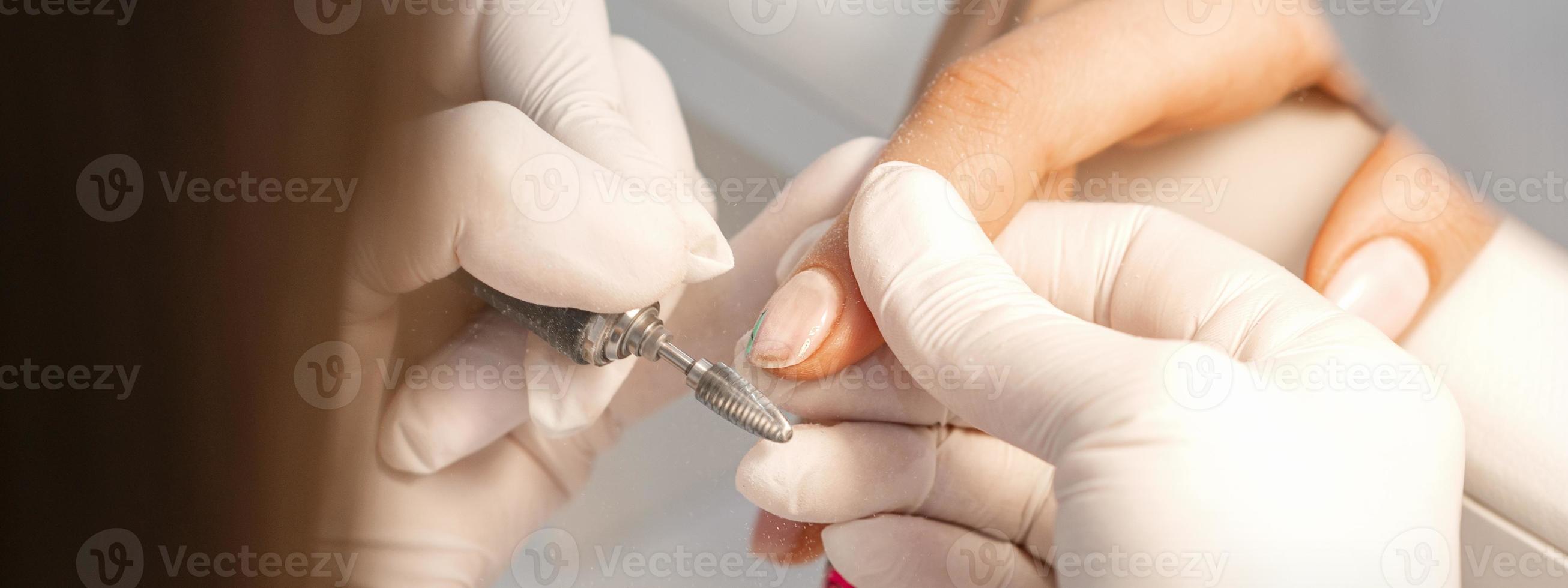 Manicure master removes nail polish photo