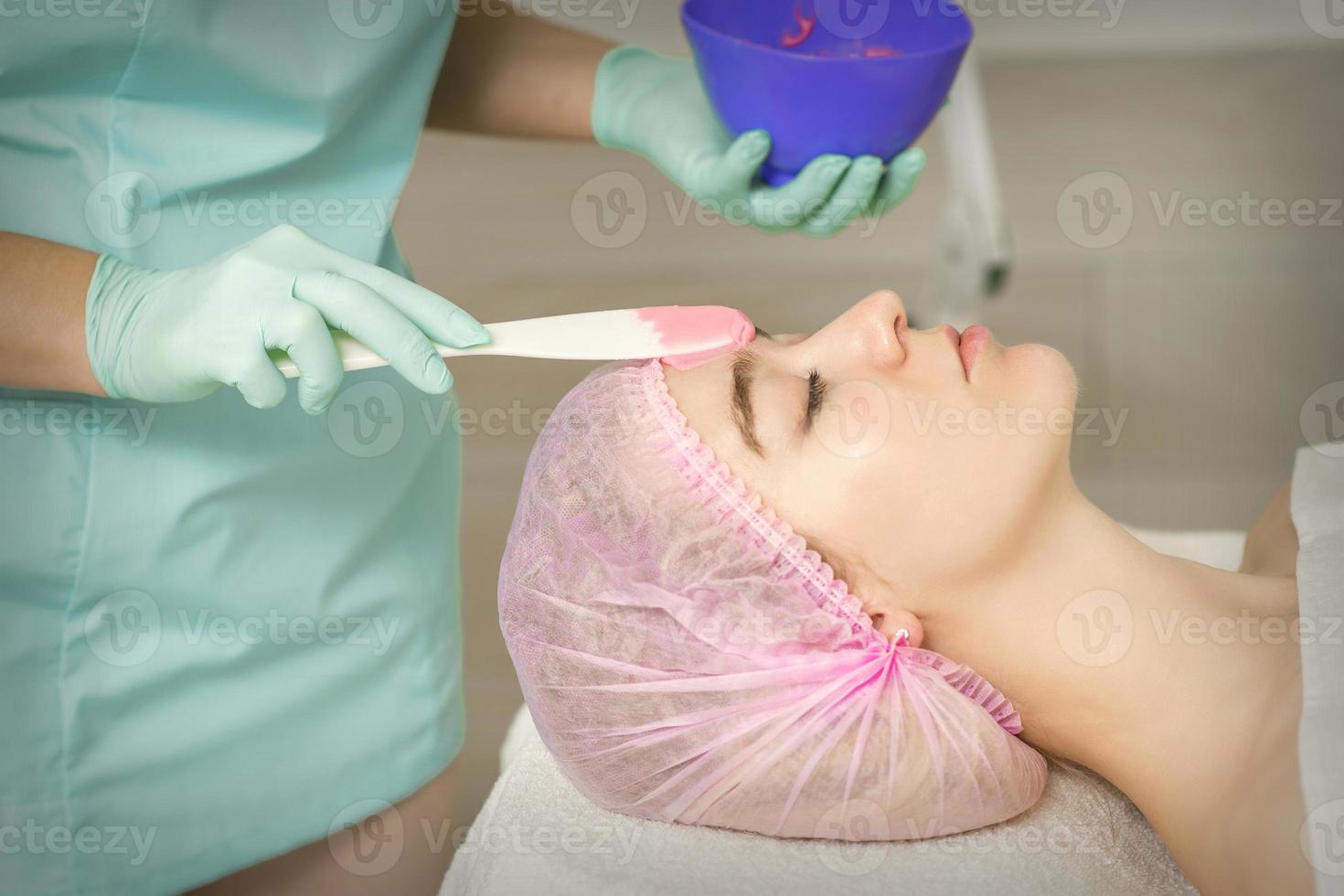 Hand applying alginate mask on face photo