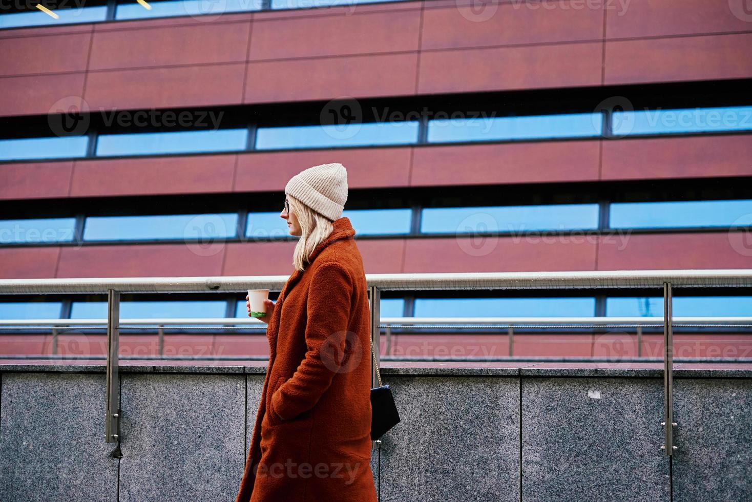 mujer en la calle de la ciudad con taza de café foto