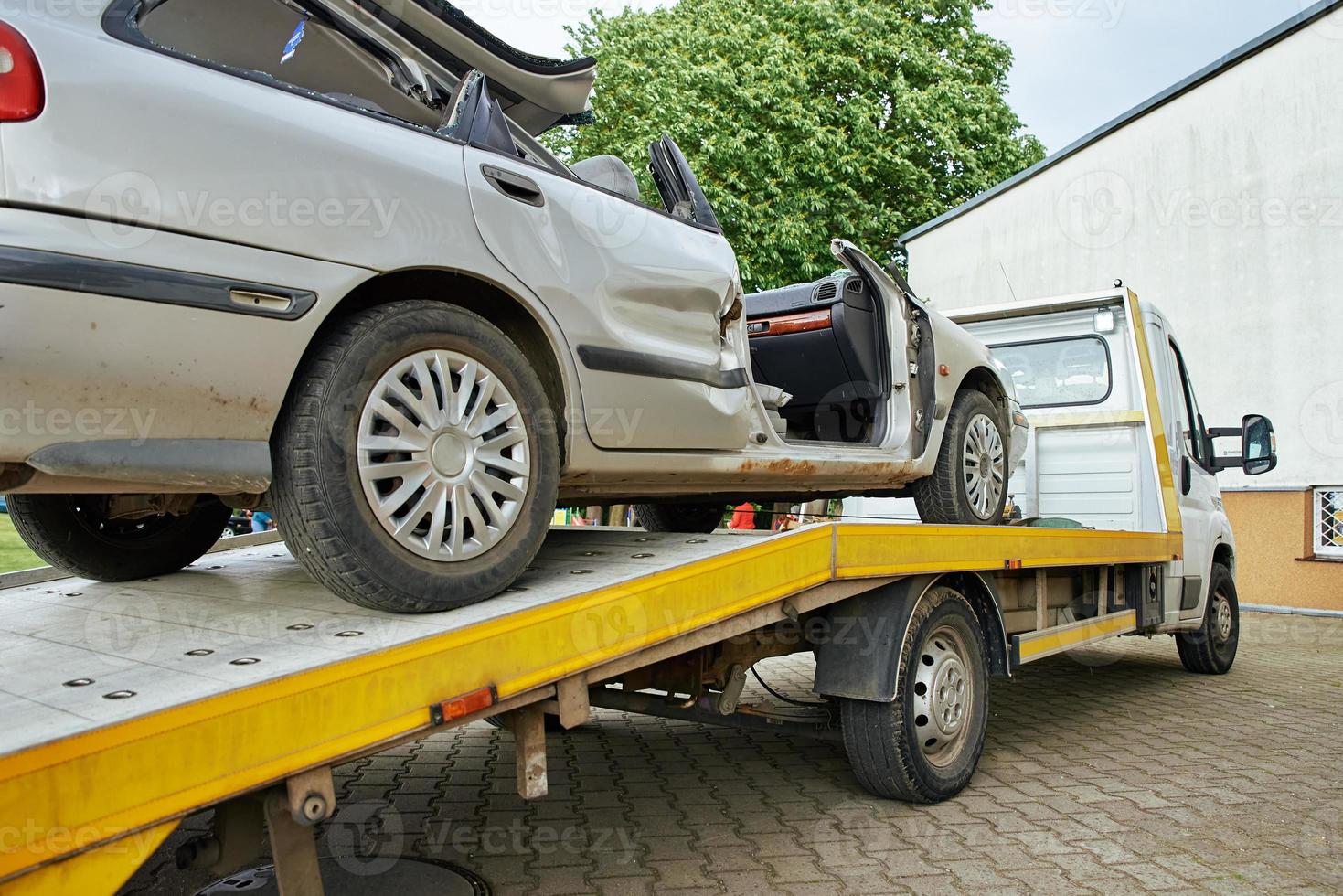 Crashed car loading into tow truck after traffic accident on road photo