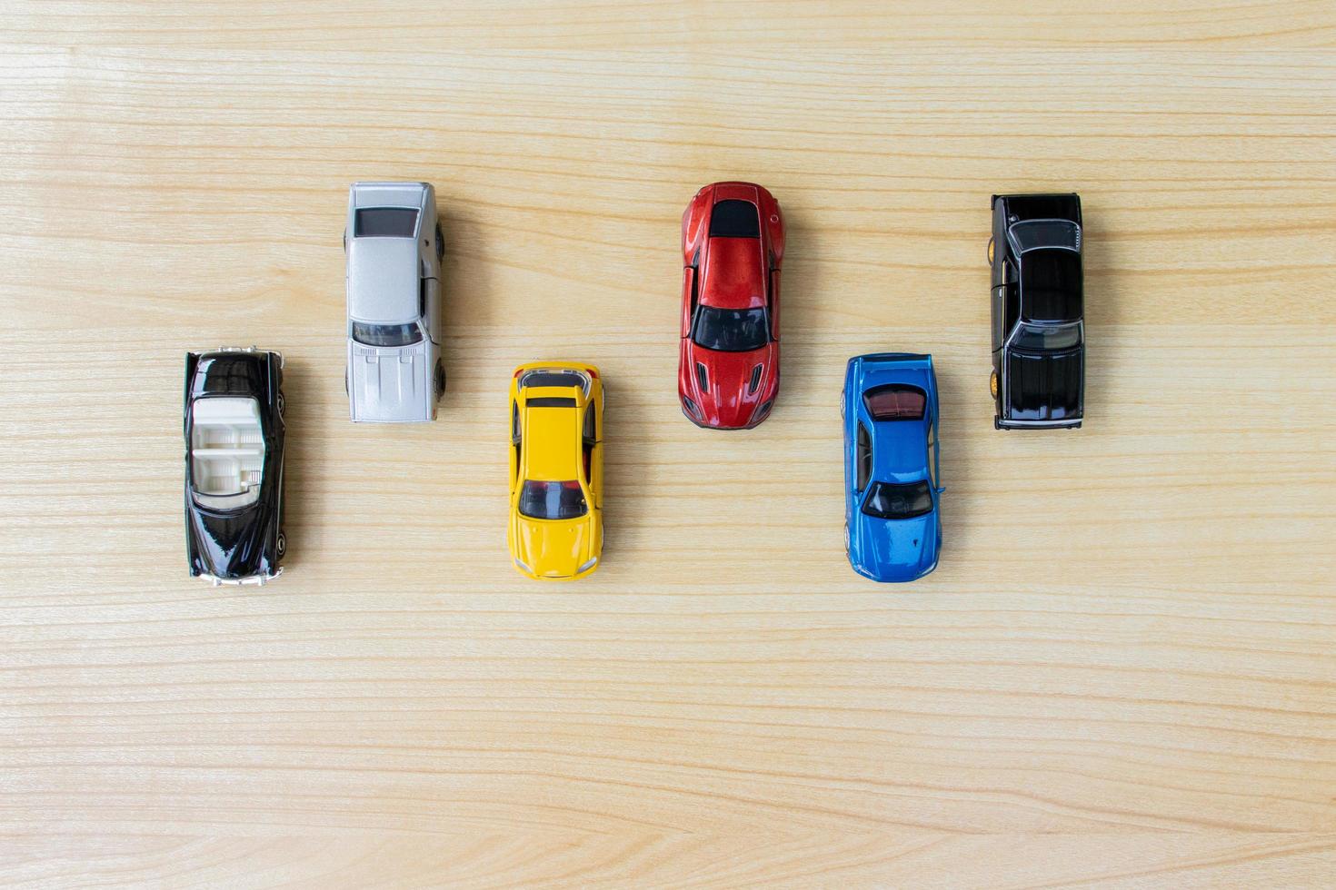 Group of toy cars isolated on wooden background, after some edits. photo