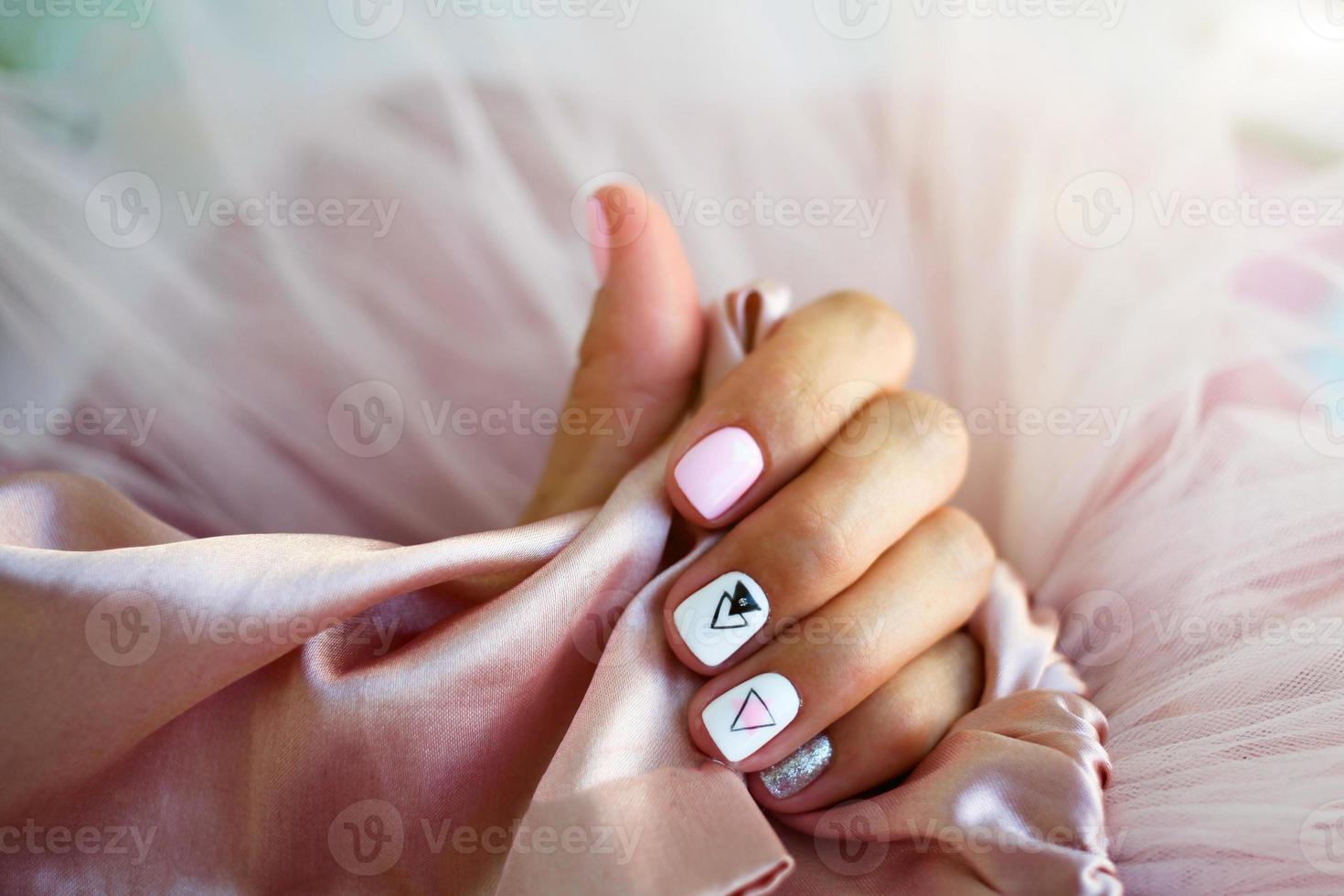 Female hands with a beautiful manicure on a pink background. photo