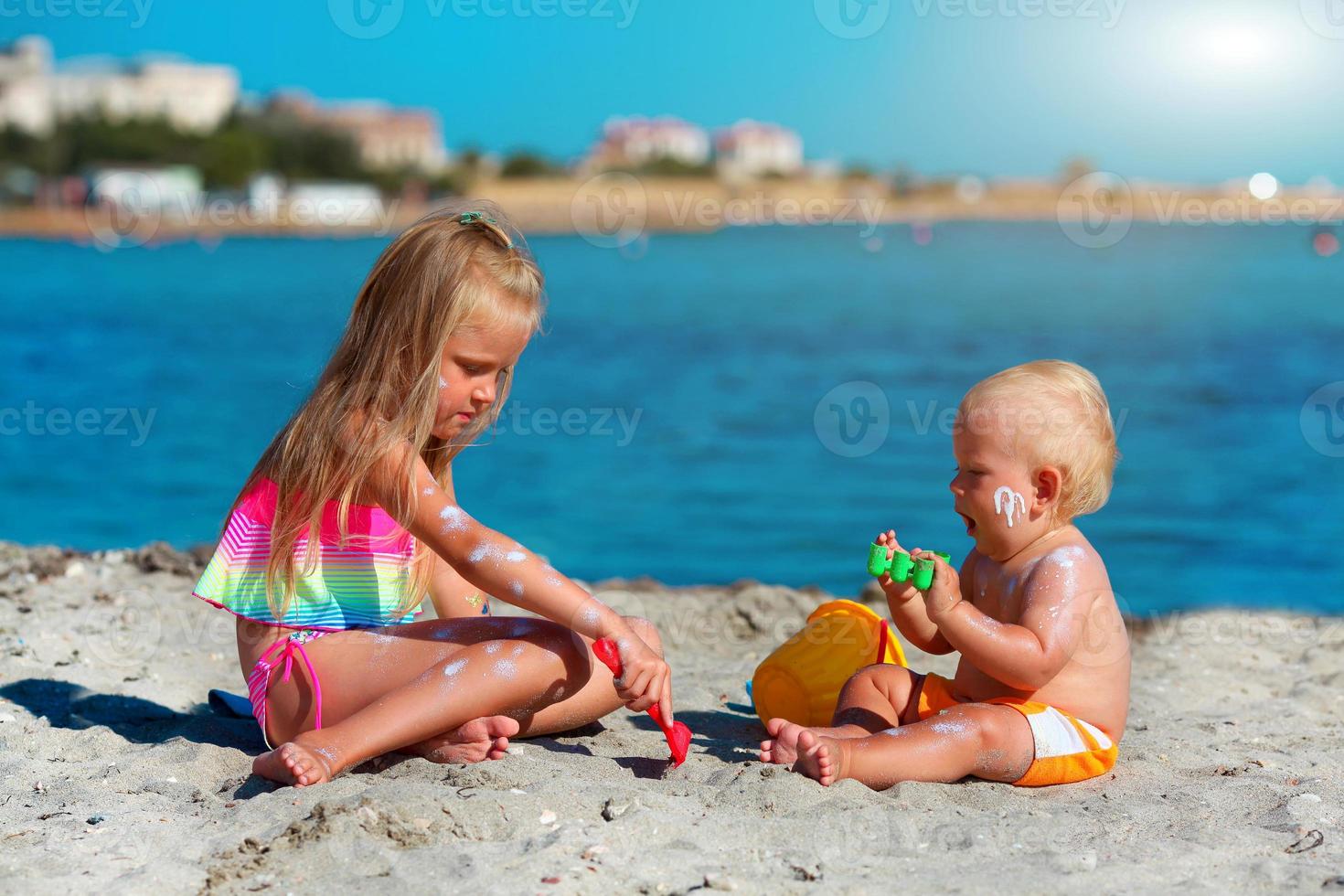 Children play on the beach. Sunscreen applied to children is skin photo