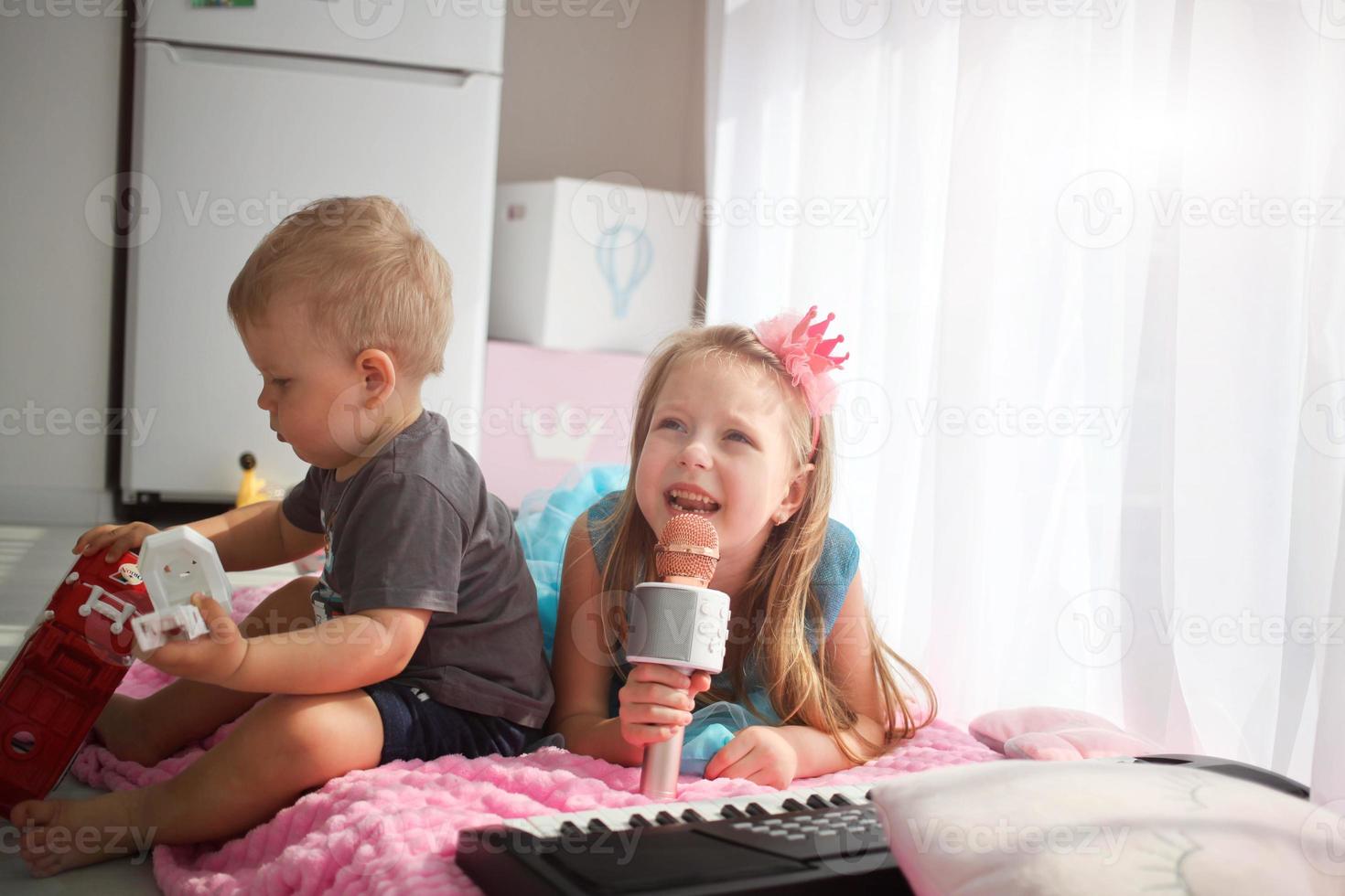 un niña en el imagen de un princesa canta dentro un micrófono. karaoke a hogar foto