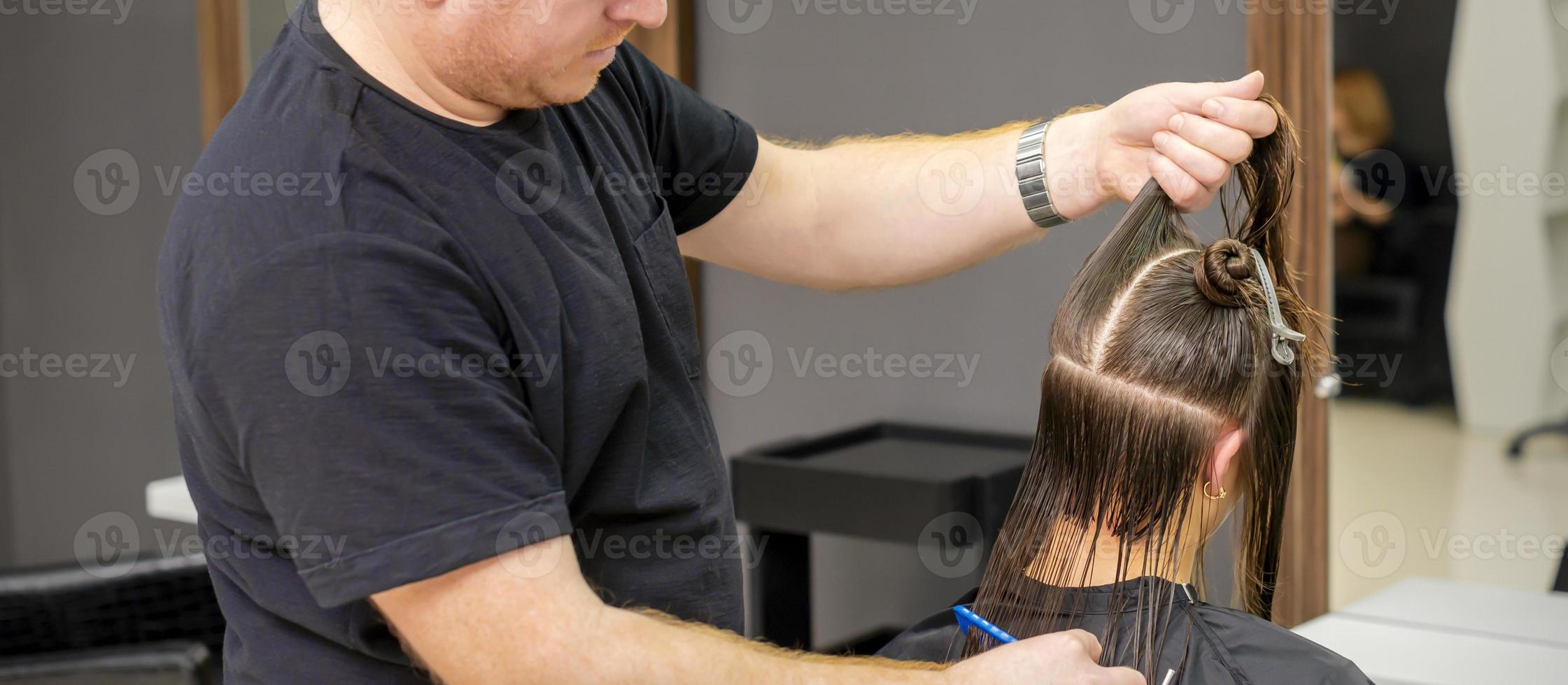 Male hairdresser splits long hair photo