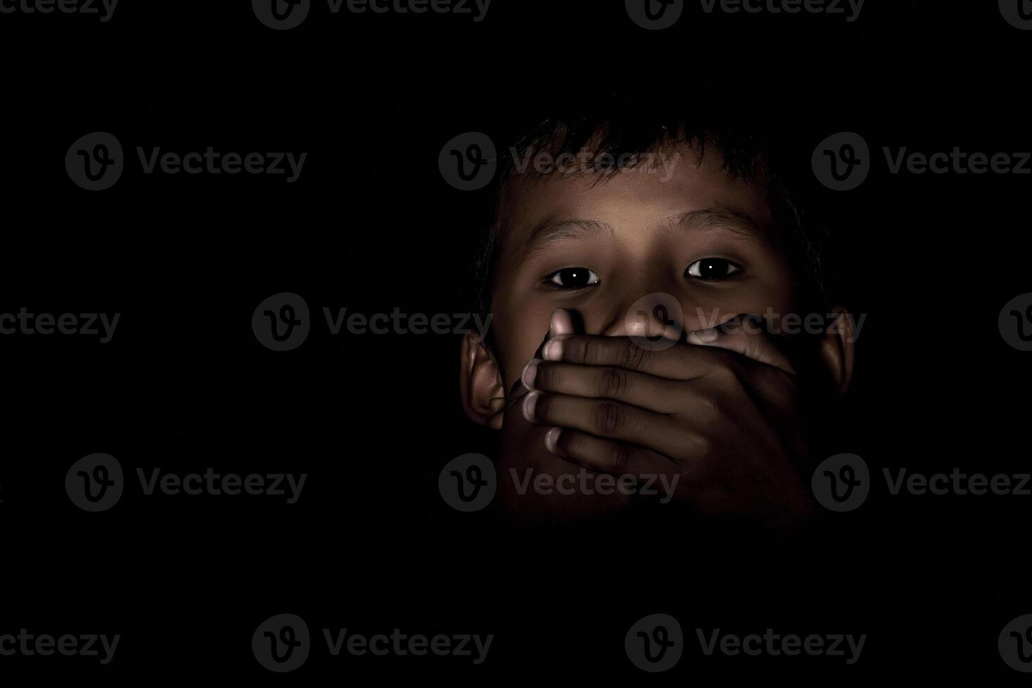 chico amordazado en el oscuro. foto