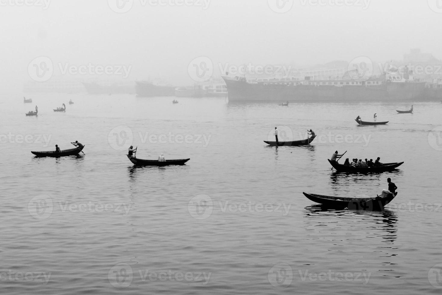 In the midday afternoon, people are crossing the river by boat and this year the fog of the winter is engulfed in the river Buriganga. photo