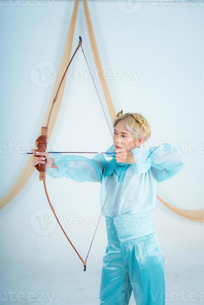 an Asian woman with blonde hair holding an arrow while wearing a blue dress photo