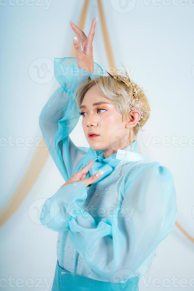 close up photo of an Asian woman with short blonde hair and wearing a blue dress