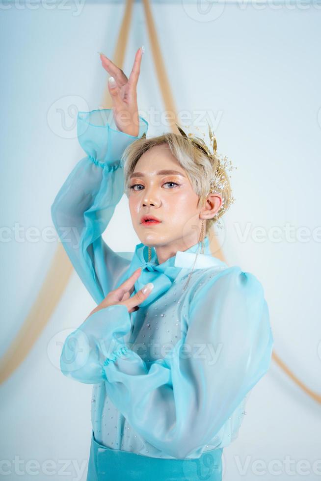 close up photo of an Asian woman with short blonde hair and wearing a blue dress