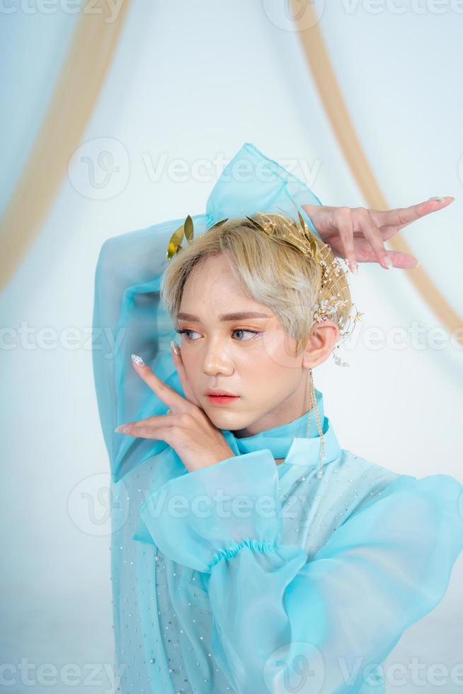 a royal princess in a blue dress posing with her hands very elegantly photo