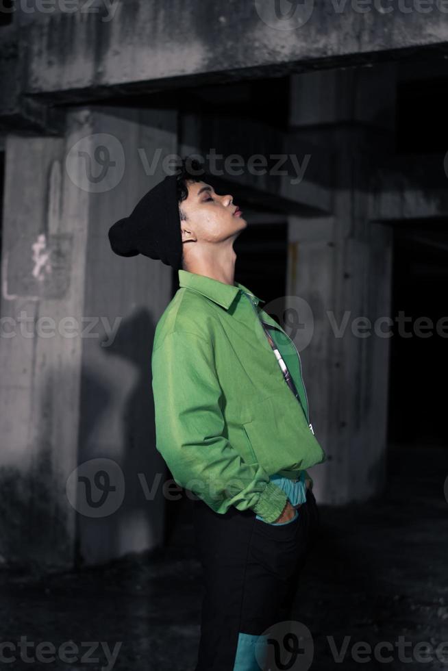 an Asian man wearing a green jacket and black beanie photo