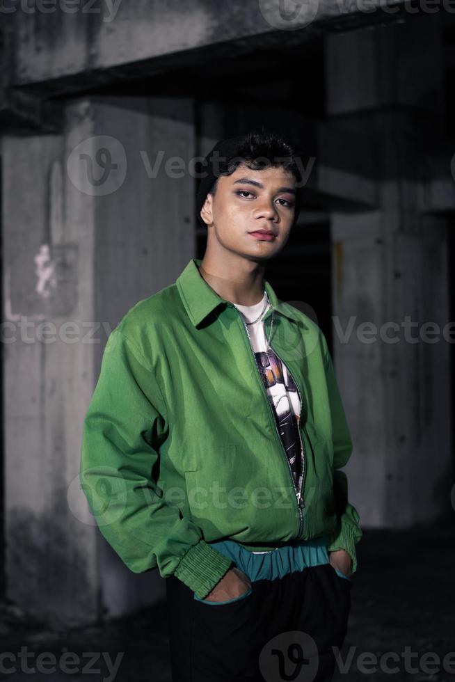 an Asian man is standing in an abandoned building in an eccentric outfit photo